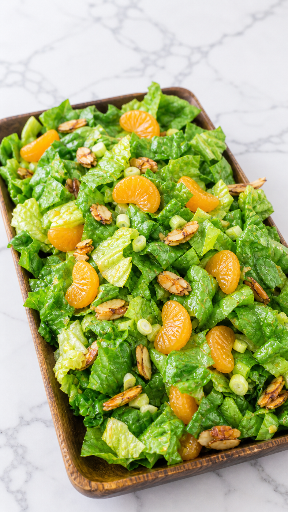 Finished mandarin orange salad with candied sliced almonds and citrus vinaigrette