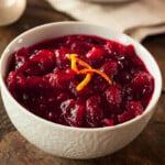 A bowl of homemade cranberry sauce with orange zest on top.