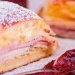 Monte Cristo Sliders dusted in powdered sugar with raspberry jam on the side.