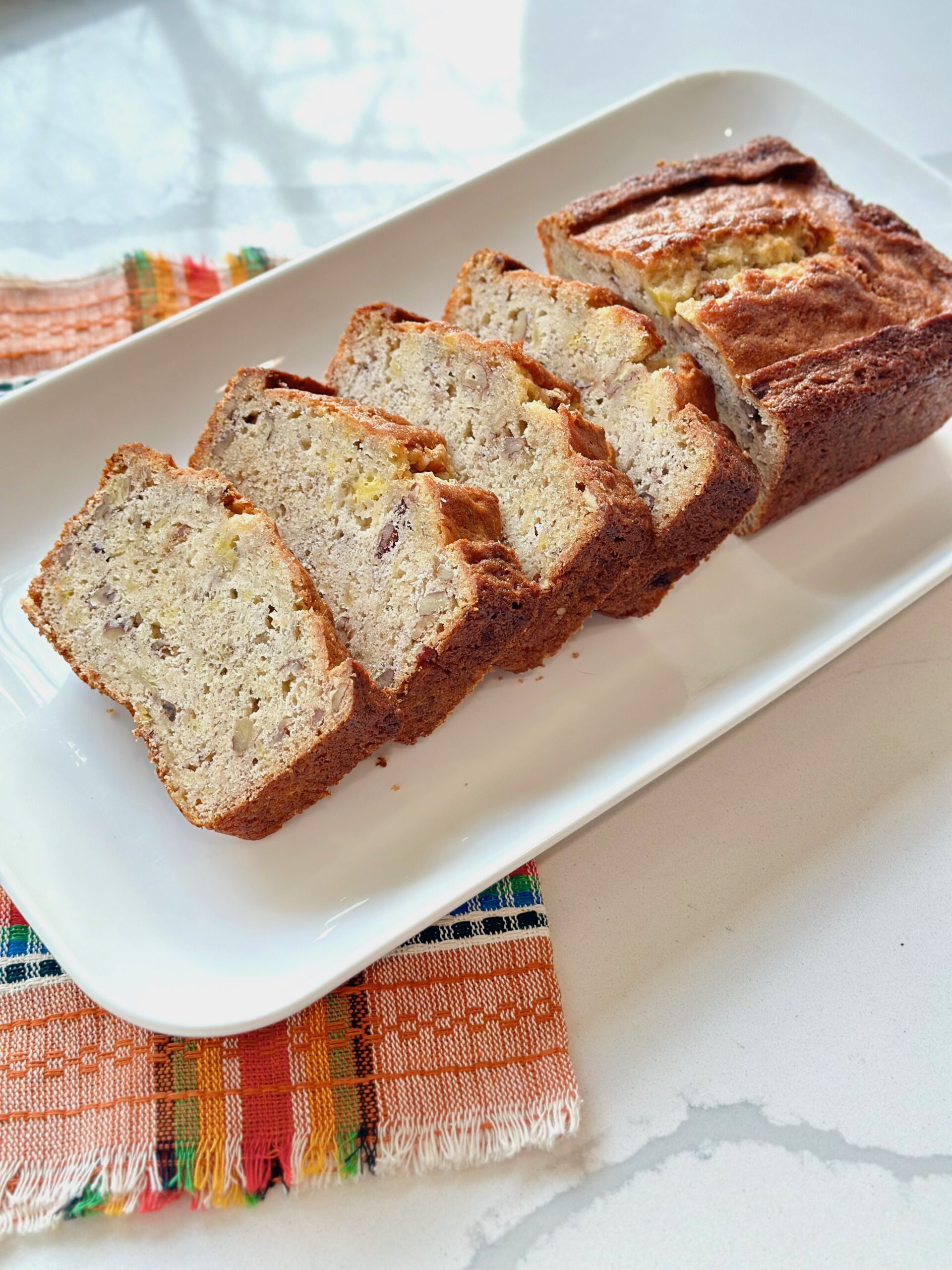A sliced  loaf of The Best Hawaiian Banana Nut Bread with Pineapple