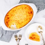Golden brown jiffy corn casserole in an oval baking dish. This corn pudding is perfect for holidays or weeknight meals.