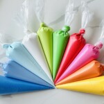 Piping bags full of vibrant colored royal icing for cookie decorating.
