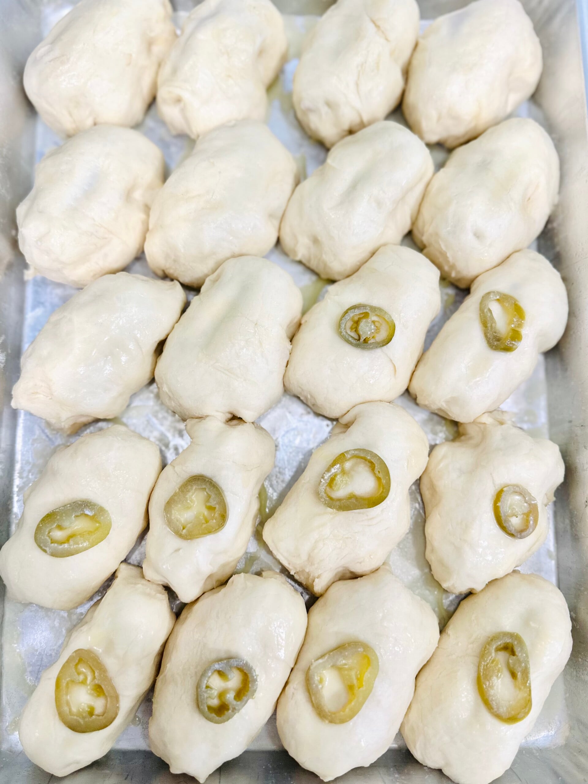 The fully prepared sausage kolaches on a sheet pan ready to bake.