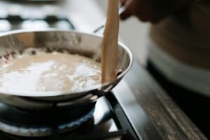 cooking a sauce over a gas burner