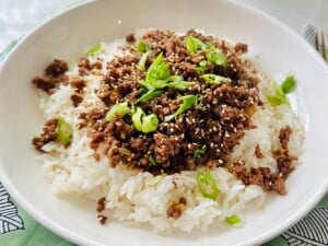 Korean Beef Bowl topped with toasted sesame seeds and sliced green onion.