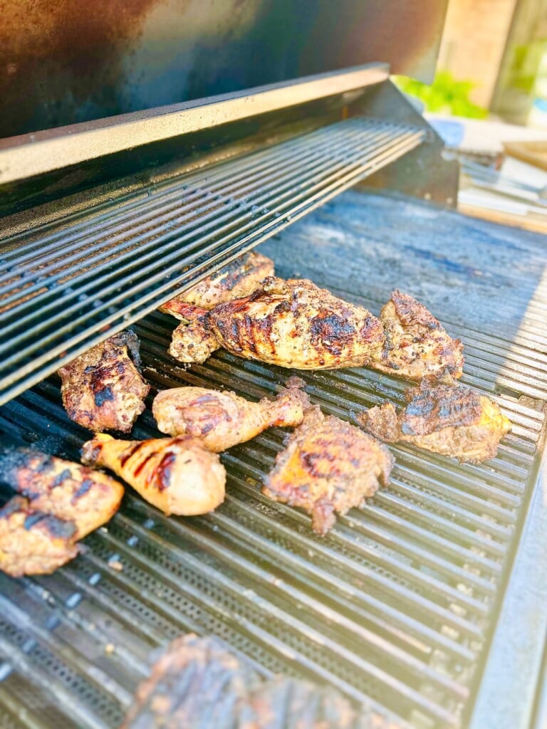 Grilled Caribbean jerk chicken on a charcoal grill with smoky char marks