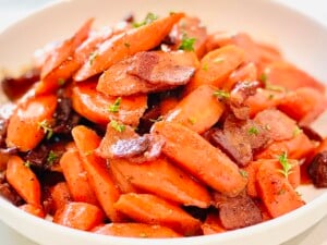 Simple glazed carrots recipe made with Dijon mustard, honey, and bacon, ready to serve for dinner or entertaining.