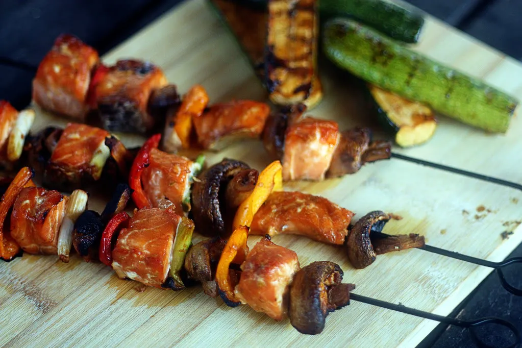 Skewers of honey-lime salmon kabobs grilled to perfection with zucchini and mushrooms
