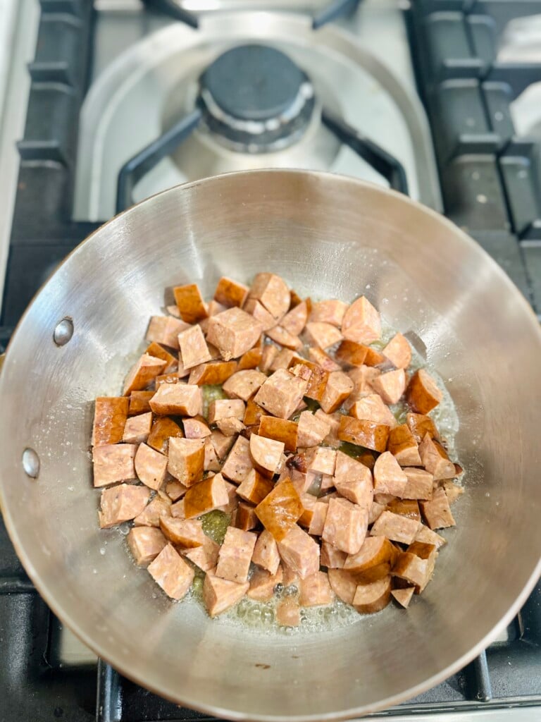 Sauteeing bacon in a skillet for shrimp and sausage jambalaya