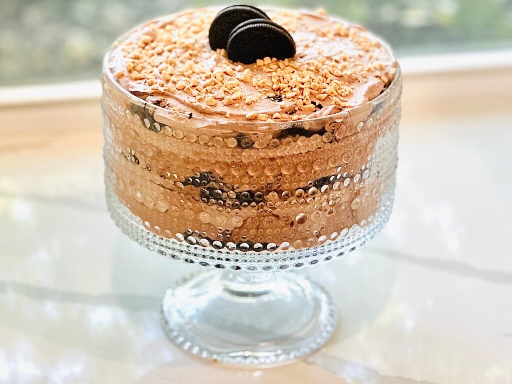 Creamy Baileys chocolate dessert layered with Oreos, cheesecake filling, and whipped cream, finished with toffee topping