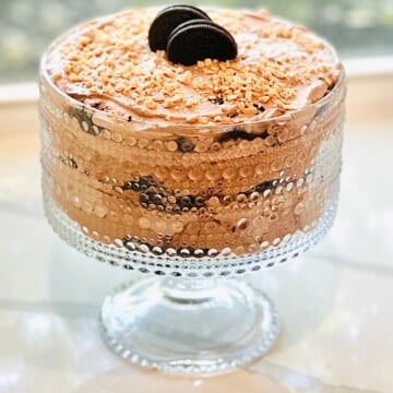 Creamy Baileys chocolate dessert layered with Oreos, cheesecake filling, and whipped cream, finished with toffee topping