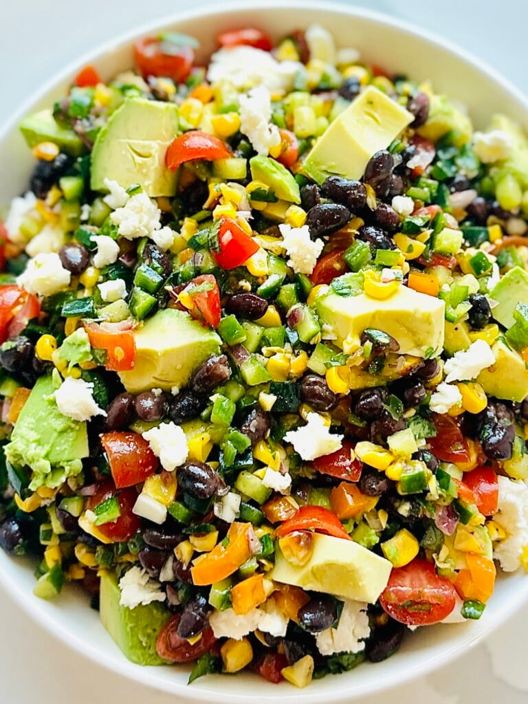 Overhead view of colorful Mexican chopped salad with fresh vegetables, queso fresco, and tortilla strips