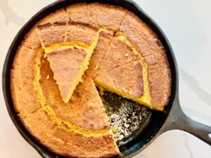 Golden Southern buttermilk cornbread baked in a cast iron skillet, sliced into wedges with a crisp crust.