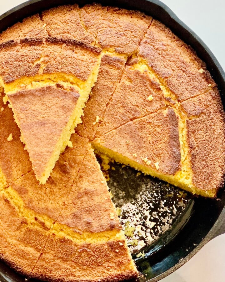 Golden Southern buttermilk cornbread baked in a cast iron skillet, sliced into wedges with a crisp crust.
