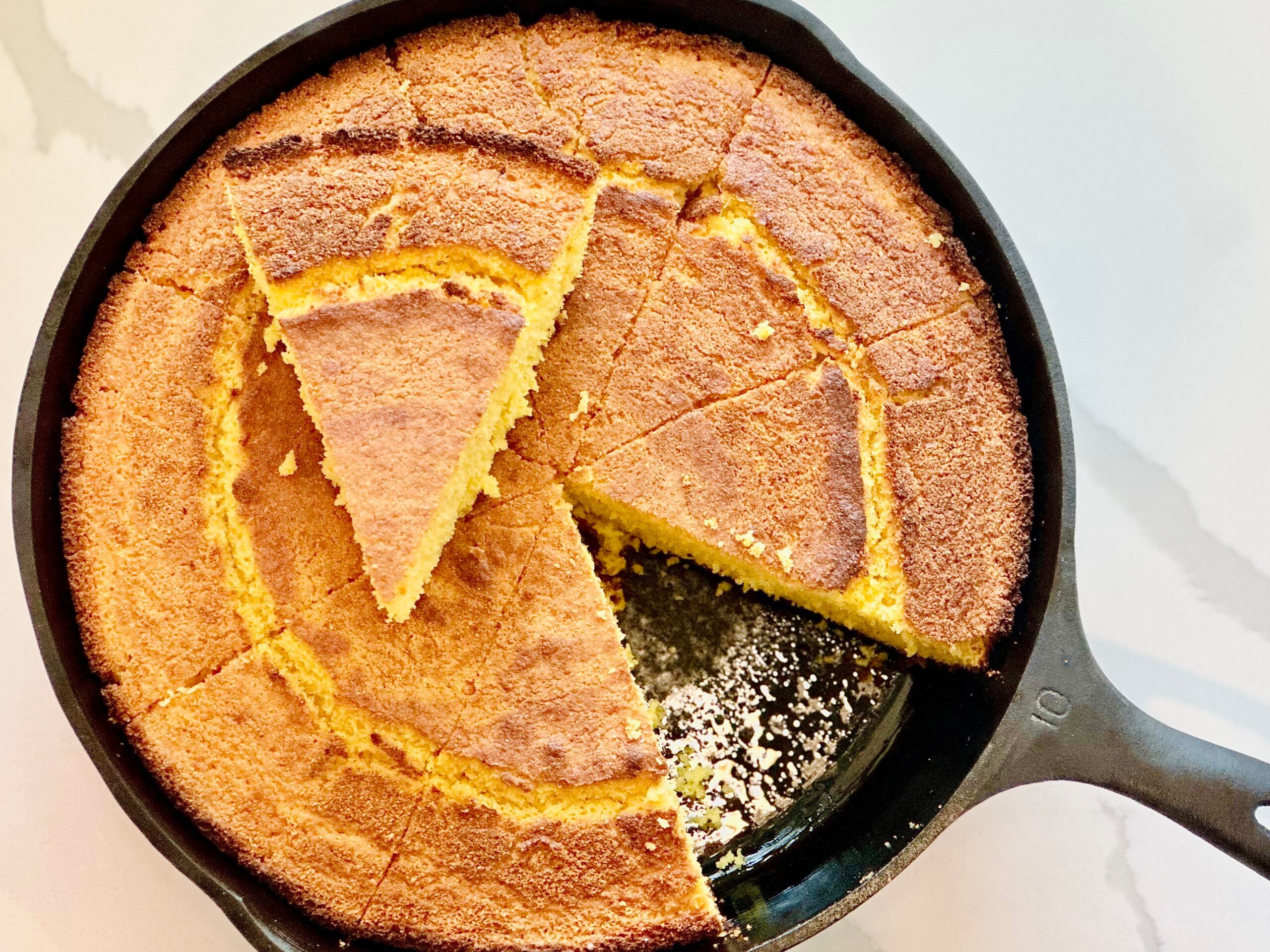 Golden Southern buttermilk cornbread baked in a cast iron skillet, sliced into wedges with a crisp crust.
