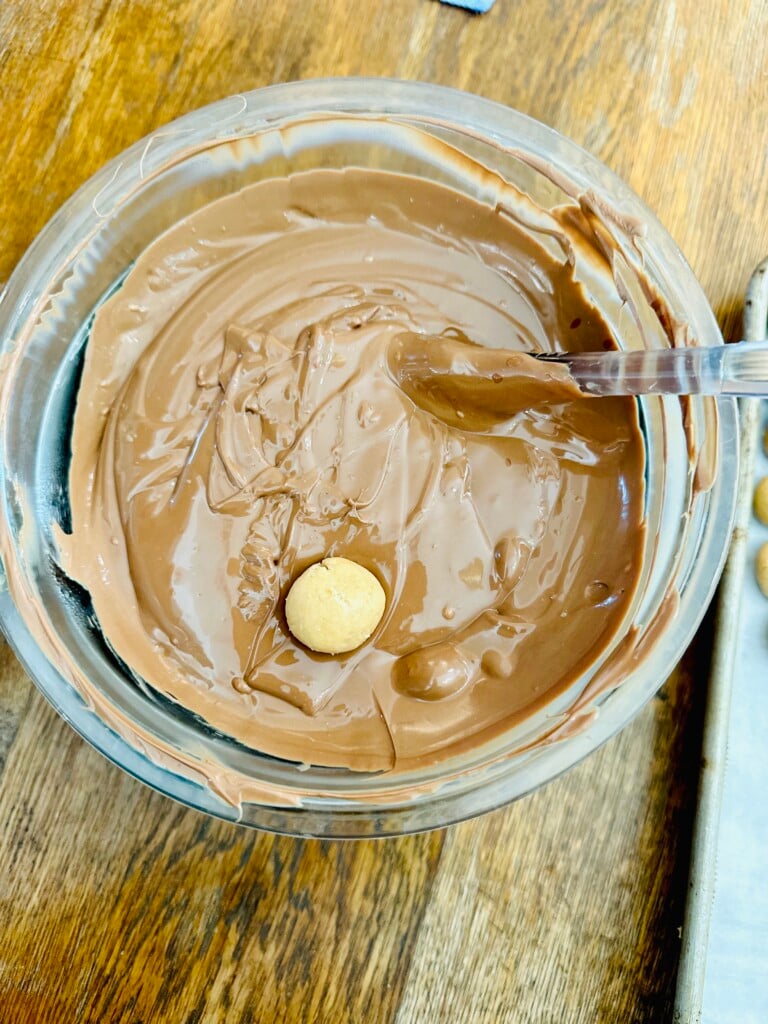 Peanut Butter balls being dipped in chocolate.