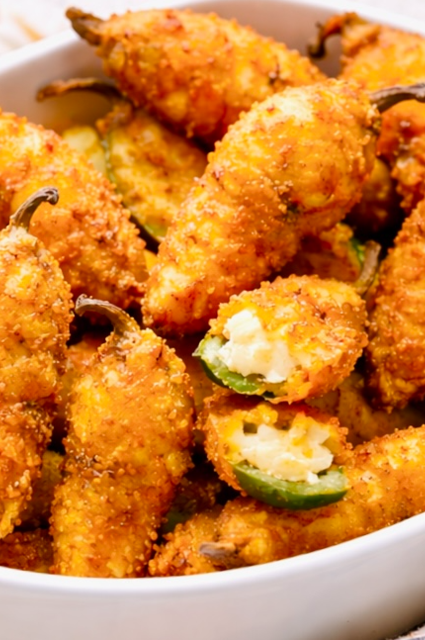 Close-up of crispy fried jalapeño poppers showing the creamy cheese filling inside a breaded jalapeño pepper