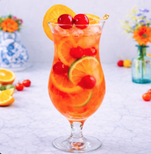 Single hurricane cocktail in a clear hurricane glass with ice, citrus slices, and maraschino cherries, photographed in bright natural light on a marble surface.