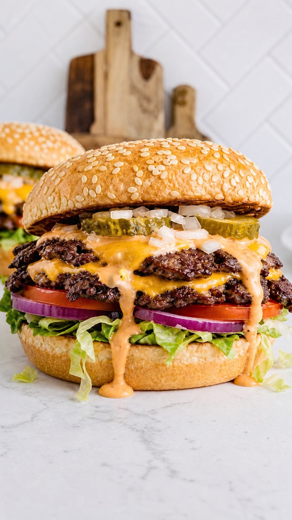 Finished double smash burger with crispy edges, melted cheddar, pickles, lettuce, tomato, onion, and burger sauce
