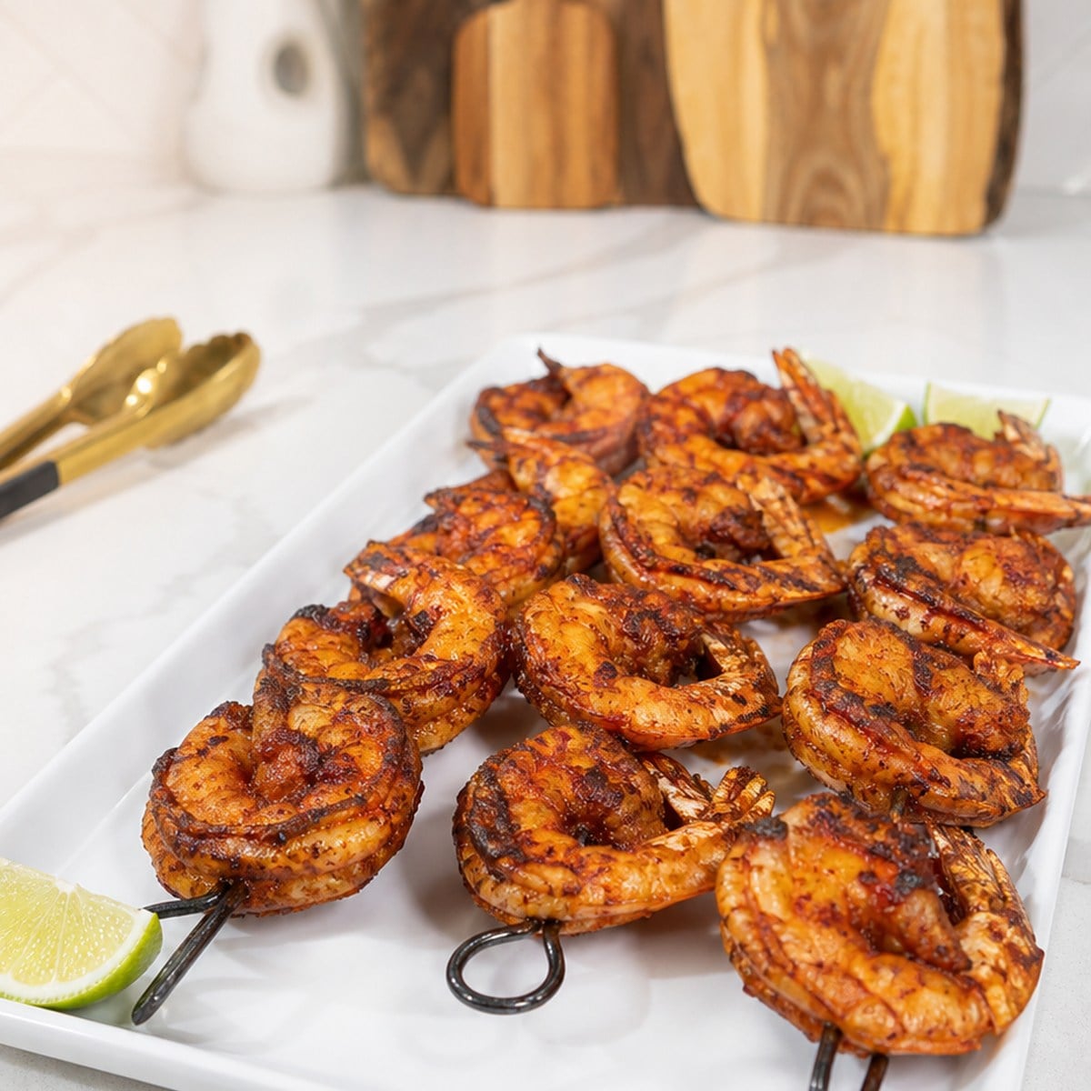 Finished BBQ grilled shrimp skewers on a white platter in JenniferCooks kitchen.