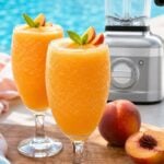 Frozen peach Bellini cocktail with fresh peach garnish by the pool.