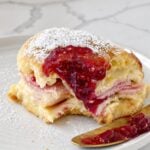 Close-up Monte Cristo slider with raspberry preserves and melted cheese.