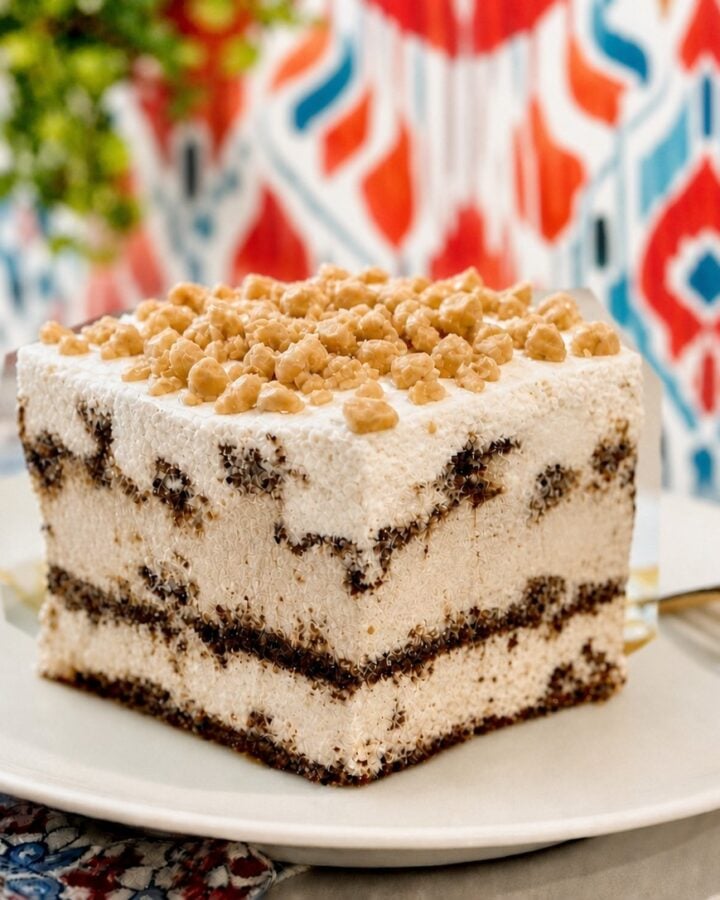 Ice cream sandwich cake slice with toffee bits on a clean plate and bright kitchen wallpaper.
