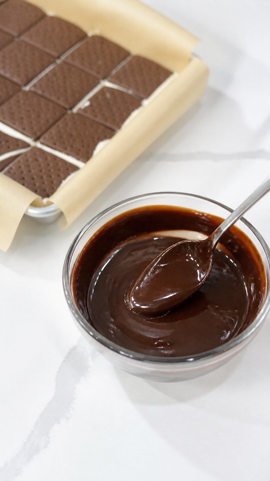 Warm hot fudge topping ready to spoon over the ice cream layer.