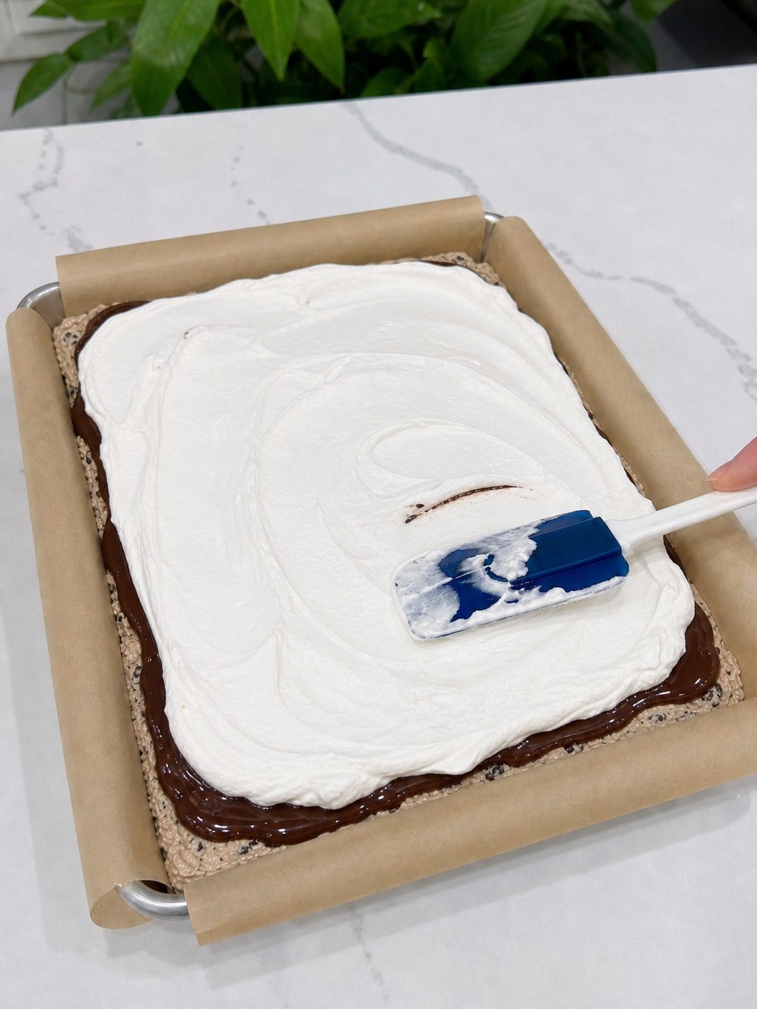 Smooth Cool Whip spread over the hot fudge layer in the ice cream sandwich cake.