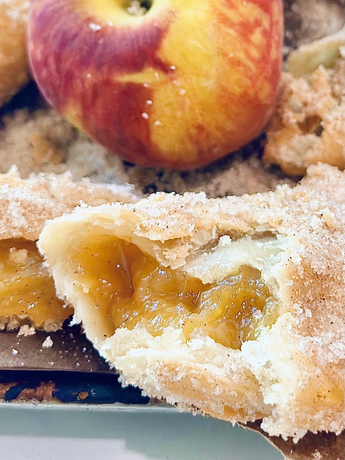 Cut-open fried peach pie showing thick peach filling inside a flaky crust.