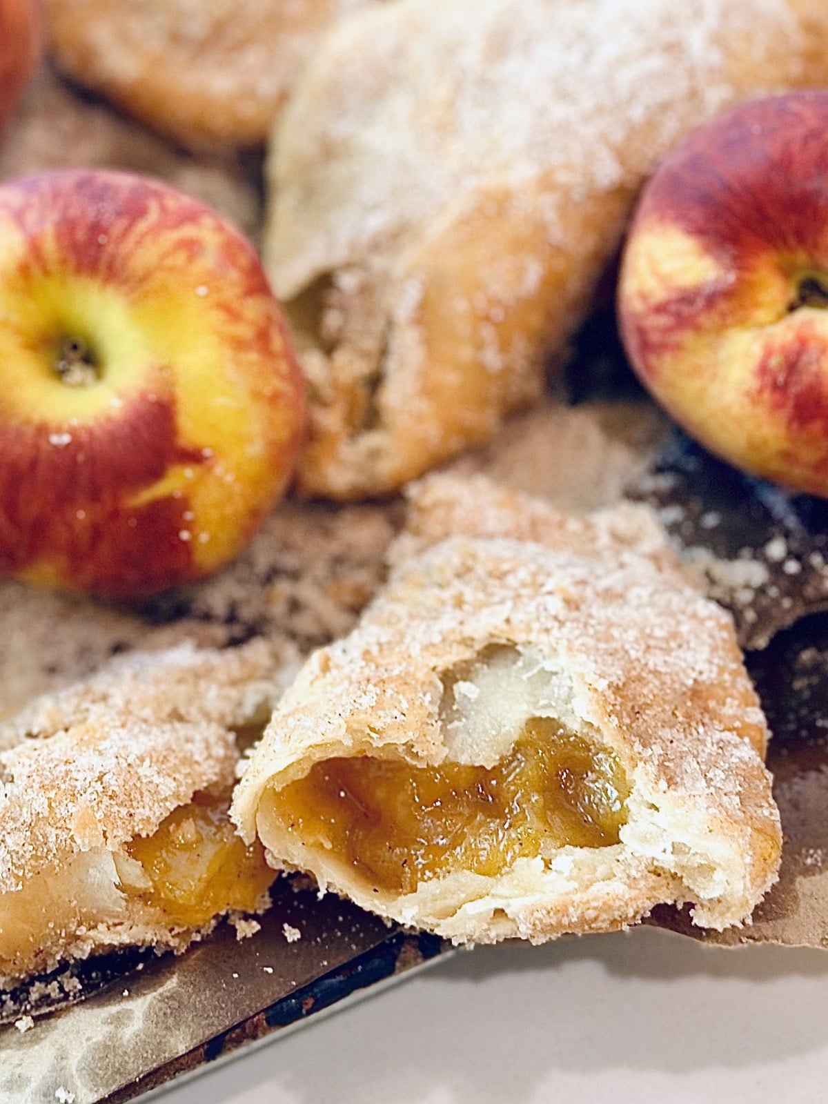 Fried peach pie cut open with golden peach filling and flaky crust.
