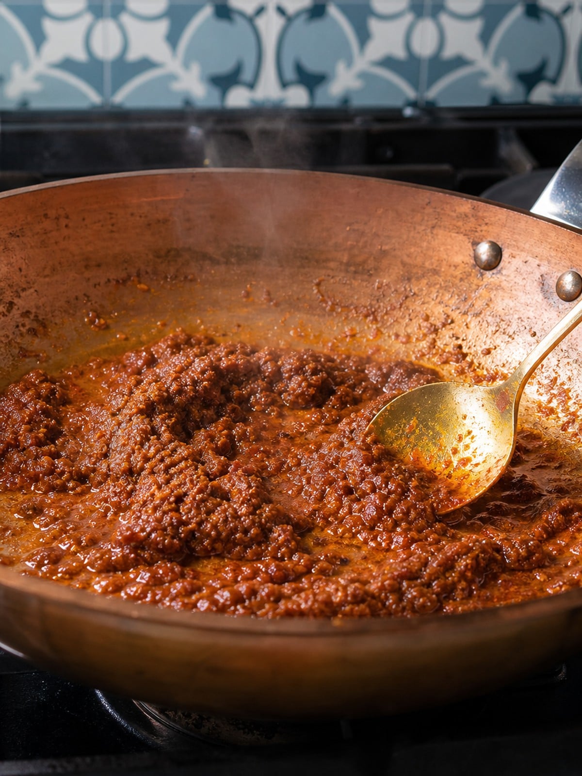 Massaman curry paste, ginger, lemongrass, and tamarind blooming in a copper skillet.