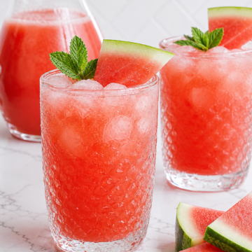 Seedless watermelon agua fresca served over ice with mint and watermelon wedges.