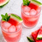 Two glasses of watermelon agua fresca with fresh watermelon and mint.