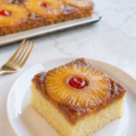 Moist fluffy slice of Pineapple Upside-Down Sheet Cake with caramelized pineapple and cherry.