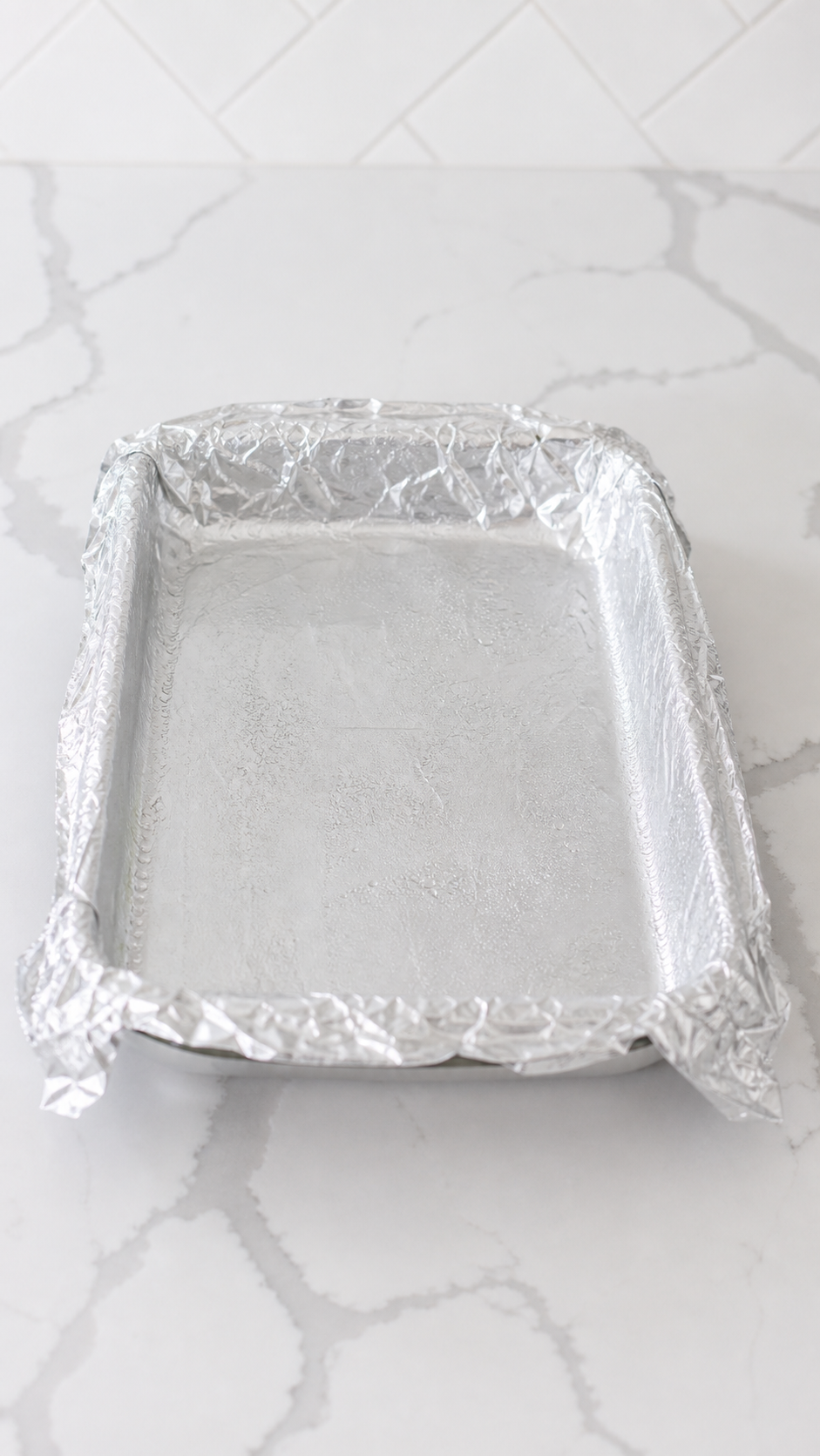 Foil-lined 9x13 baking dish prepared for Monte Cristo sliders.