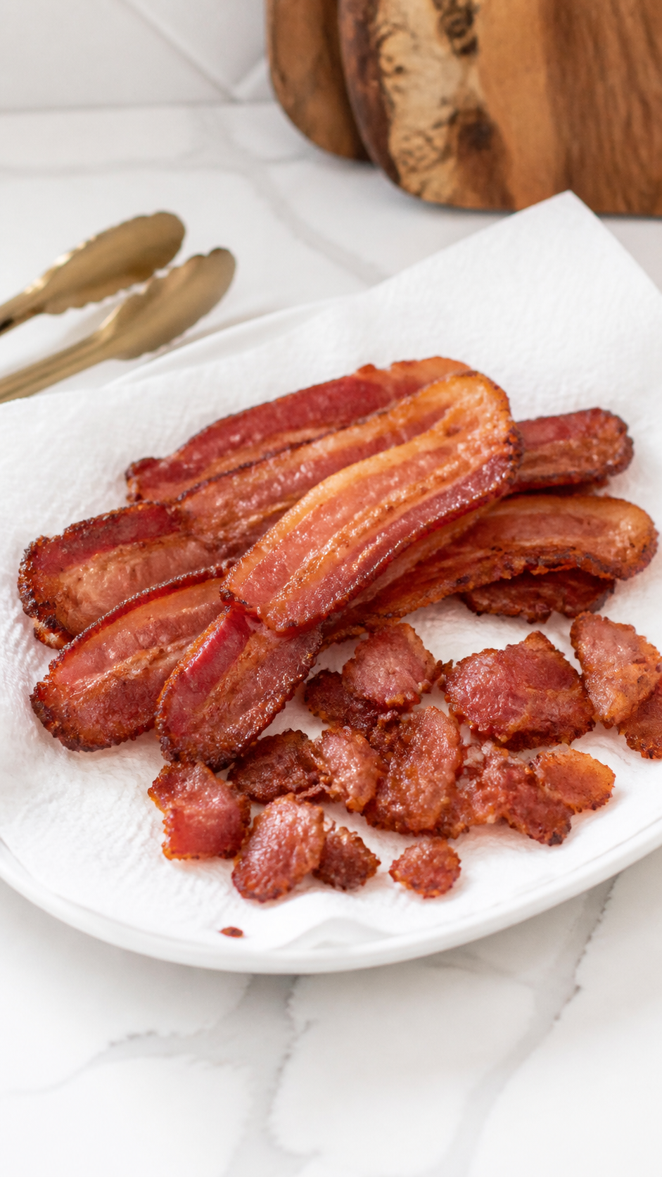 Crisp thick-cut bacon draining on a paper towel-lined plate for BBQ bacon pasta salad.