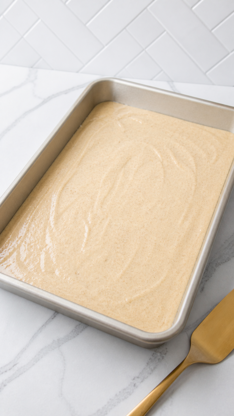 Smooth Bisquick cobbler batter spread evenly in a 9x13 baking dish.