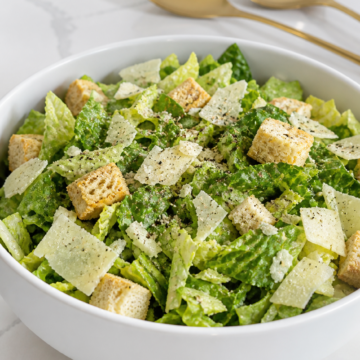 Classic Caesar salad lightly seasoned with salt and freshly ground black pepper before dressing.