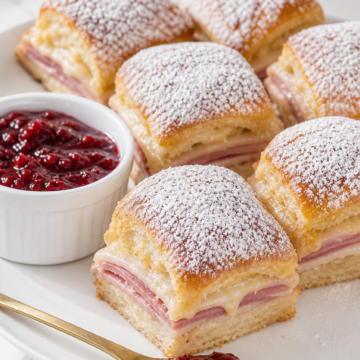 Finished Monte Cristo sliders with powdered sugar and raspberry preserves.