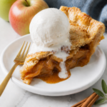 Classic apple pie slice with flaky crust, cinnamon apple filling, vanilla ice cream, apples, cinnamon, and lemon.
