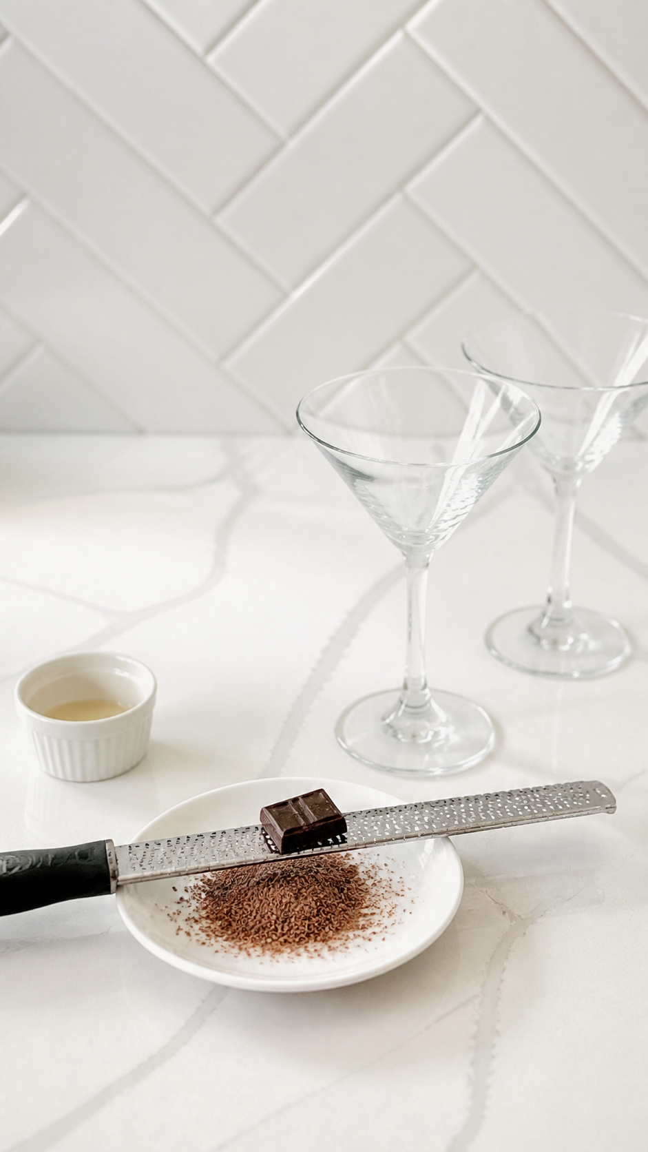 Dark chocolate finely grated onto a white saucer for espresso martini rims.