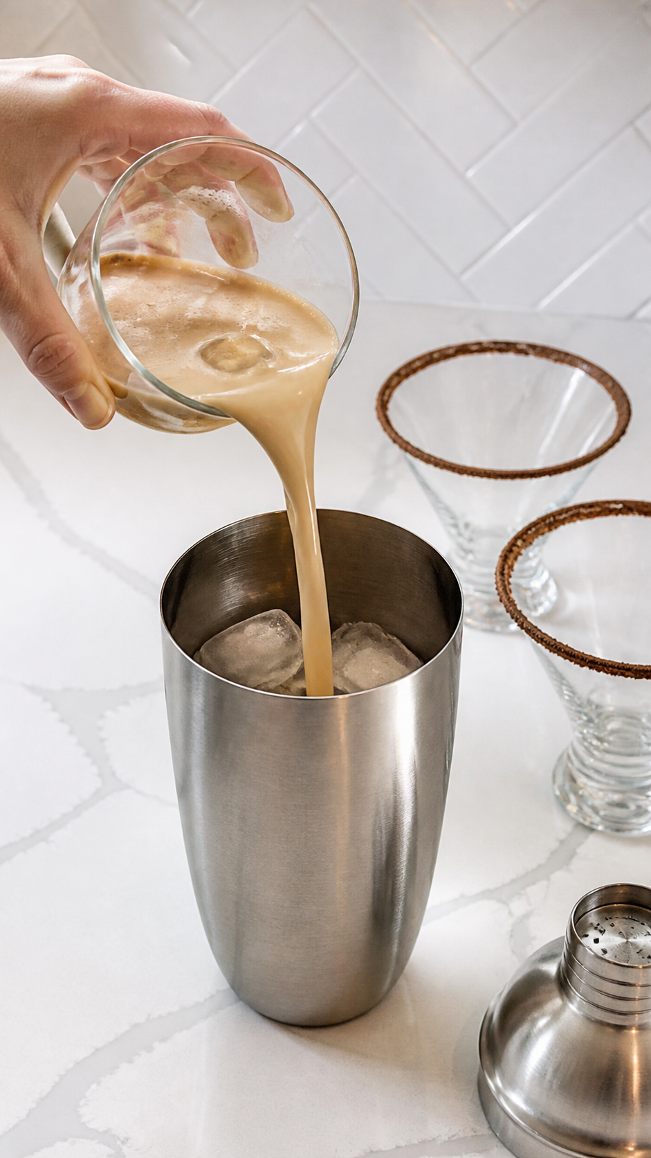 Creamy coffee cocktail mixture poured into an ice-filled cocktail shaker.