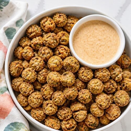 Close-up of deep golden fried okra showing its crisp cornmeal coating and green okra centers.