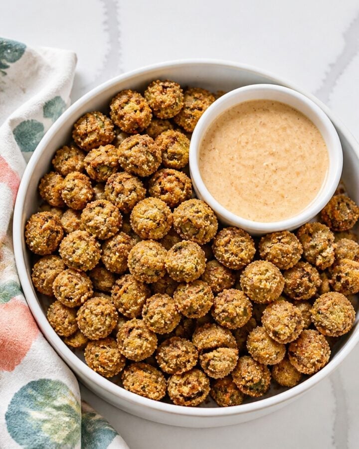 Close-up of deep golden fried okra showing its crisp cornmeal coating and green okra centers.