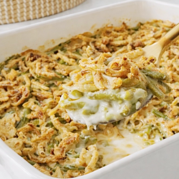 Spoonful of creamy green bean casserole with crisp fried onions.