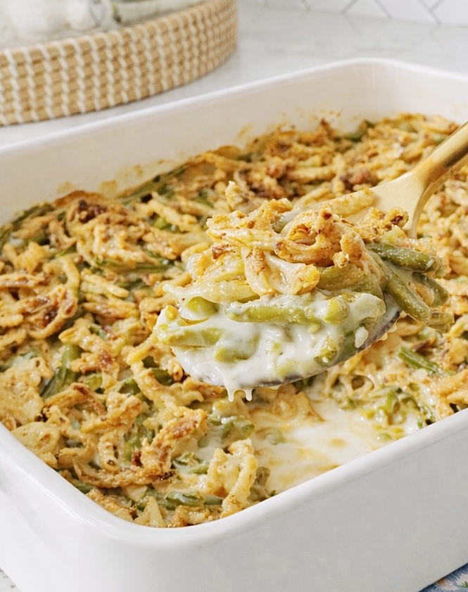 Spoonful of creamy green bean casserole with crisp fried onions.