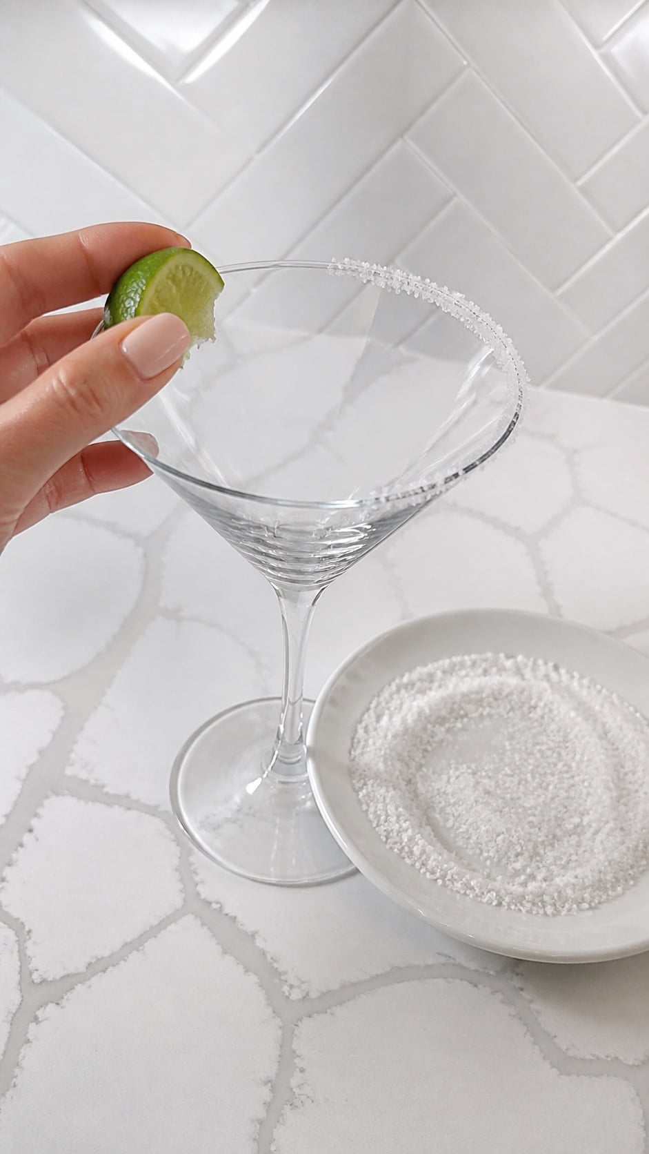 Martini glass rim moistened with a lime wedge and coated evenly with margarita salt.