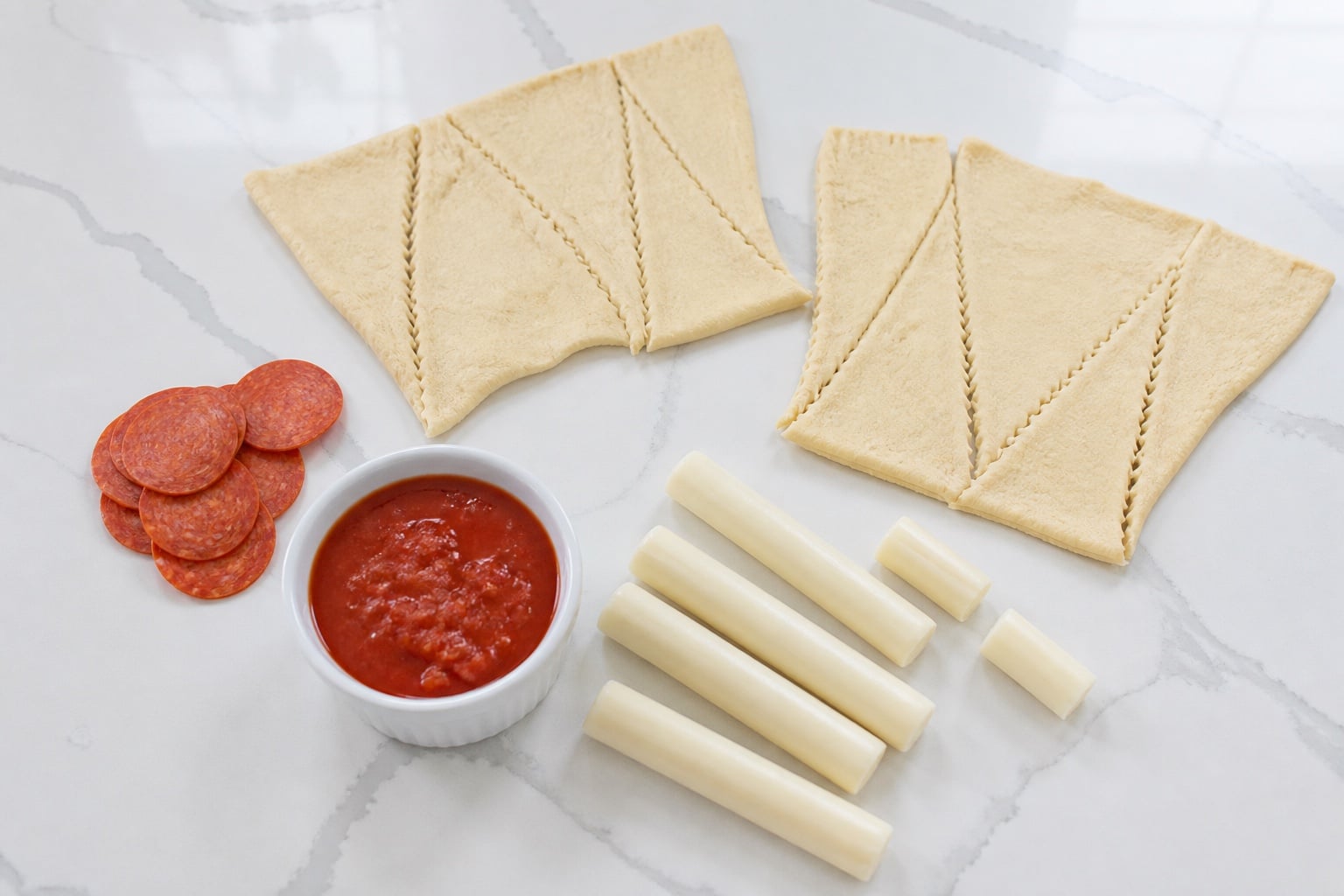 Garlic crescent dough, pepperoni, mozzarella string cheese, and marinara for pizza crescent rolls.