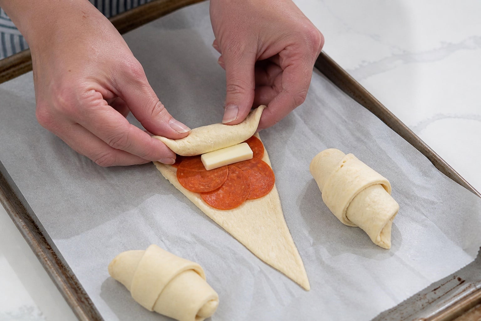 Pepperoni and mozzarella crescent roll pinched and sealed before baking.